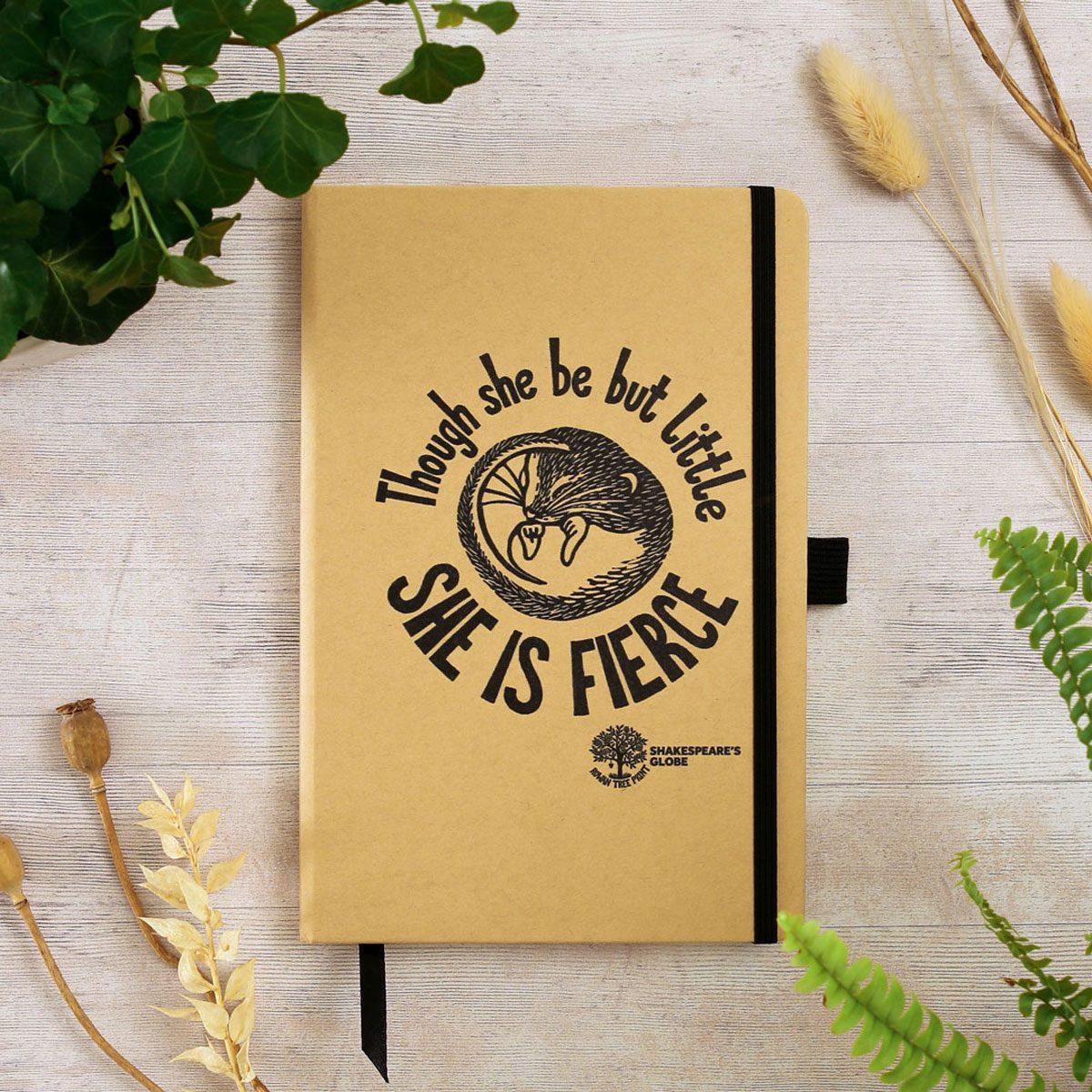 A brown notebook with a black print of a shrew and the quote 'Though she be but little she is fierce'.