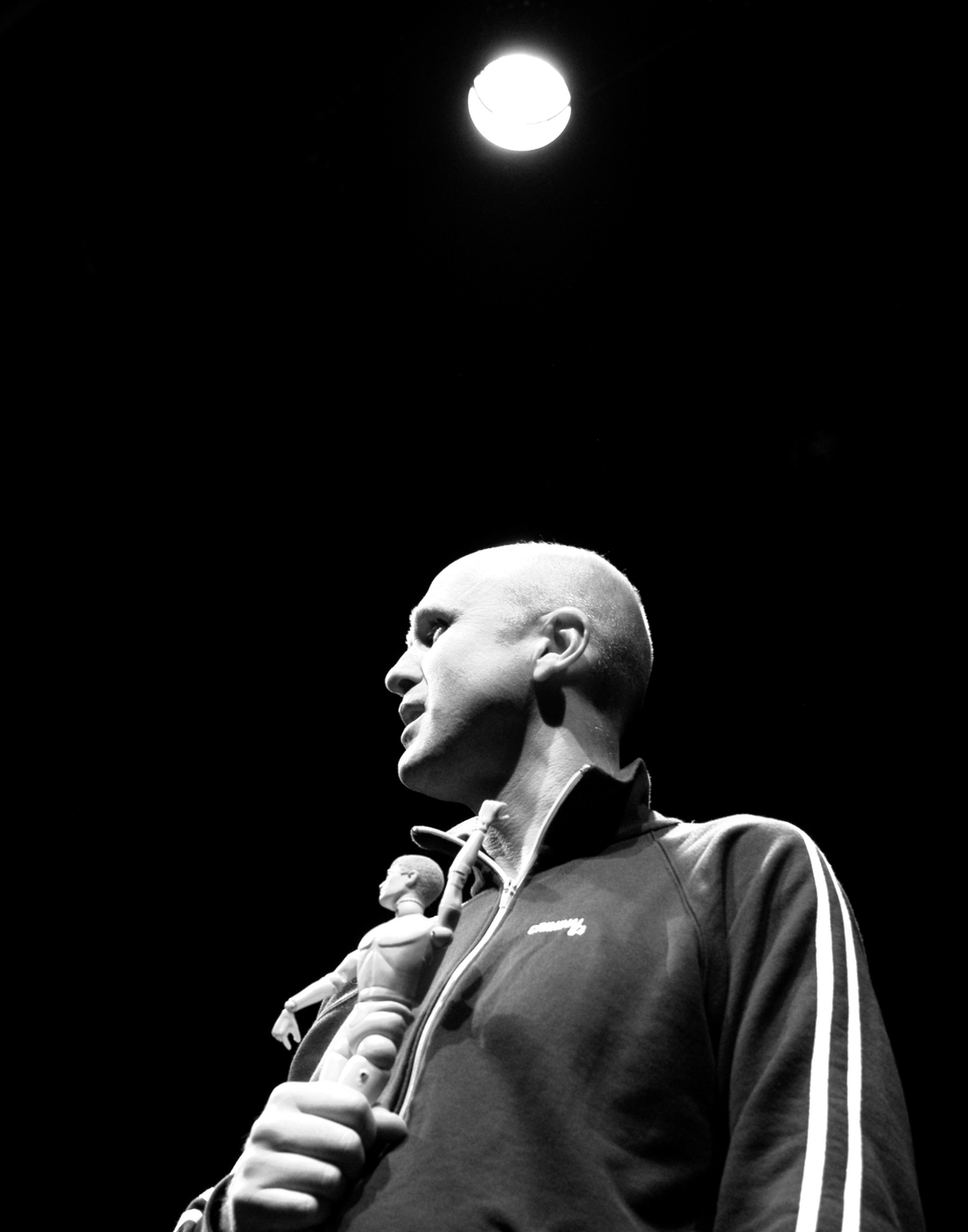 Actor Tim Crouch on stage holding a plastic doll