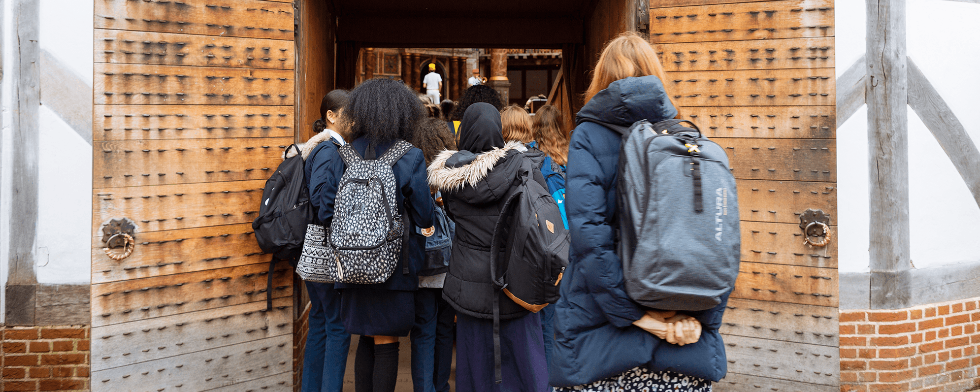 A school group walking into the yard of the Globe Theatre