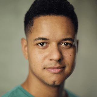 A person facing the camera wearing a turquoise t-shirt